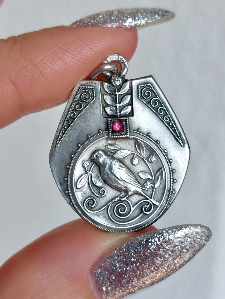 Antique Silver Pendant featuring a bird, a red paste stone and foliage with milgrain details