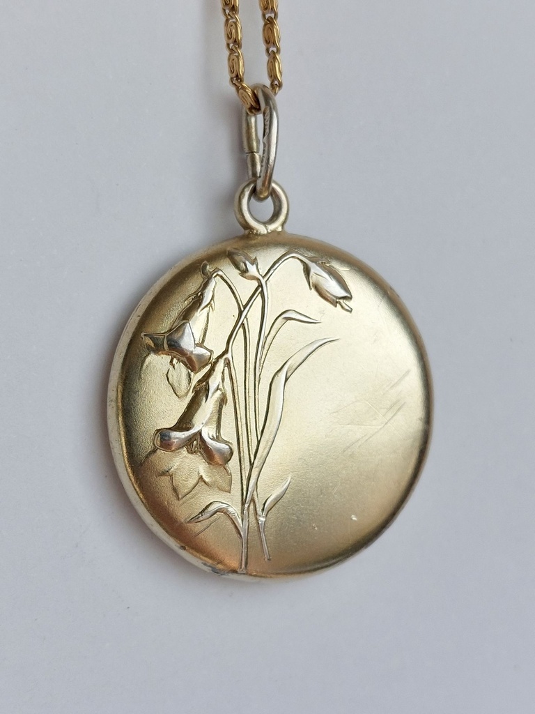 Art Nouveau silver pendant with a gold wash and repoussé flowers